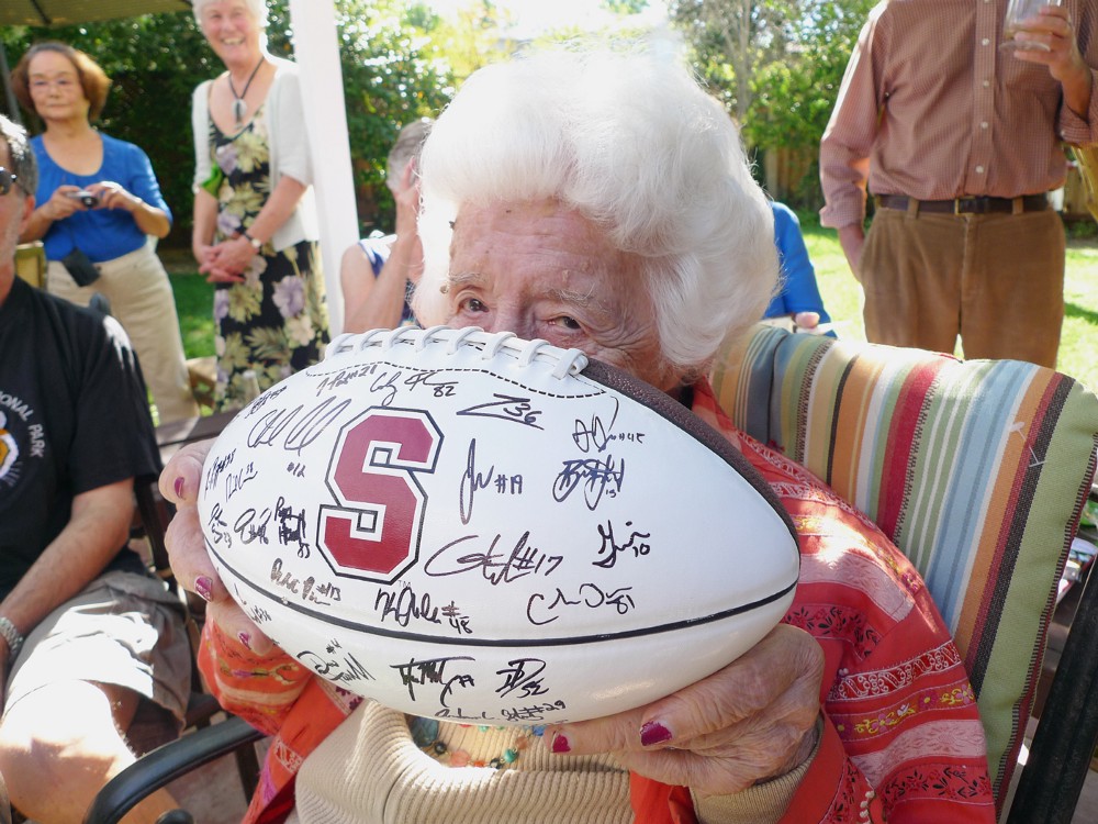 Photo of Adelaide Iverson holding a signed Stanford football