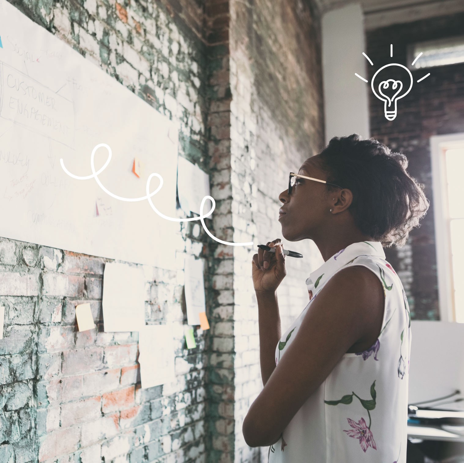 Woman standing in front of wall, writing on a white board